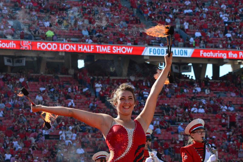 Jaycie Greenberg, a sophomore majorette studying business administration, performs in Carter-Finley Stadium by doing tricks with her batons lit on fire Saturday. In the game against Boston College, the Wolfpack lost with a score of 21-14.