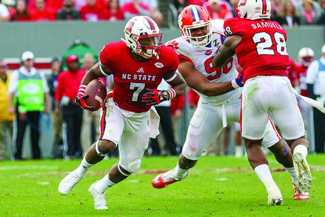 Freshman wide receiver Nyheim Hines attempts to throw the ball, decides not to then scrambles outside of the pocket against the Clemson defense. Hines finished with two receptions for 26 yards and a touchdown from the kickoff return. The Wolfpack fell to the Tigers 56-41 in Carter-Finley Stadium at NC State on Oct. 31, 2015.