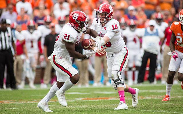 Redshirt sophomore quarterback Ryan Finley hands the ball off to senior running back Matt Dayes. The Wolfpack suffered a heartbreaking 24-17 overtime defeat at Death Valley in Clemson, SC on Saturday.&#160;