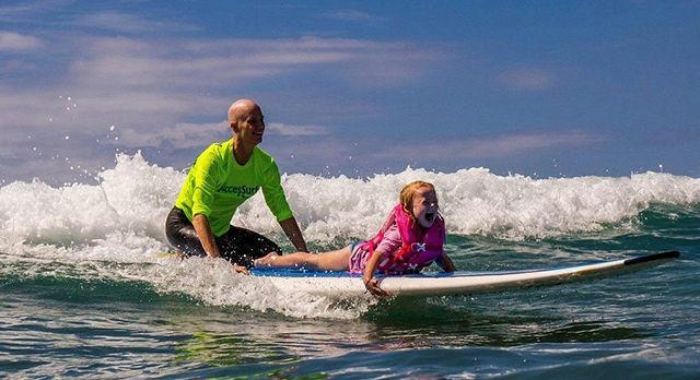 Susan Beury surfs with a child as part of the AccesSurf program.&#160;