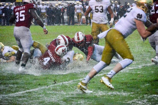 Redshirt junior linebacker Jerod Fernandez and his teammates tackle a Notre Dame ballcarrier on Oct. 8, 2017 at Carter-Finley Stadium. In a hard fought game in the midst of Hurricane Matthew, the Wolfpack beat the Fighting Irish 10-3.