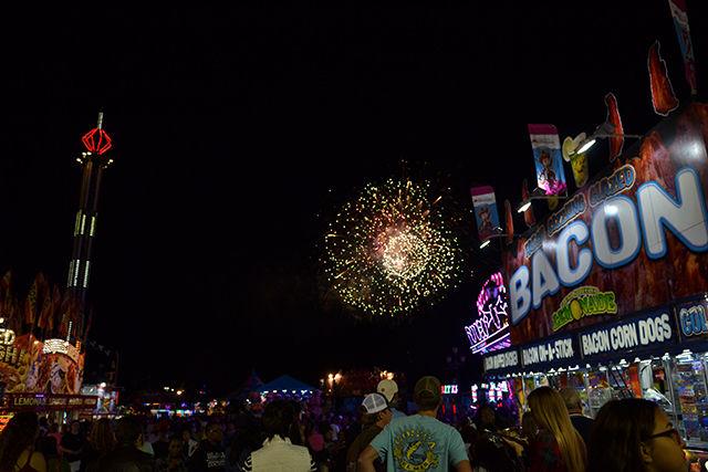 Fireworks bloom above the Midway of the North Carolina State Fair on Friday night. Thw fireworks show occurs every night at 9:45 p.m. from across the fairgrounds.