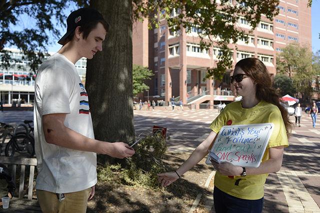 Seth Harper, a freshman studying engineering, reads his fortune from Kayla Phillips, a senior studying parks, recreation and tourism management, while she looks on at the Brickyard Wednesday. Harper's fortune was, "Life will sometimes suck, but you can get through it." Phillips is the president of the NC State chapter of the Clown Nose Club. The club originally started originally at Penn State in 2010 and the NC State chapter was established in 2011. Phillips described the club's mission as bringing joy to campus and bringing a smile to people's faces as they're walking to class. "We have a lot of fun, and we would love for people to join us," Phillips said. The club has events including High Five Giveaways and is planning on having an origami making session in Talley Student Union in November.&#160;