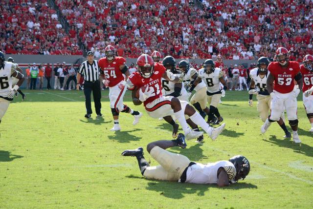 Matthew Dayes, senior running back, jumps over the Wake Forest defense during the game in Carter-Finley Stadium on Oct. 1. Dayes had 125 rushing yards and one touchdown. The Wolfpack beat the Demon Deacons, 33-16, delivering the first loss of Wake Forest's season.