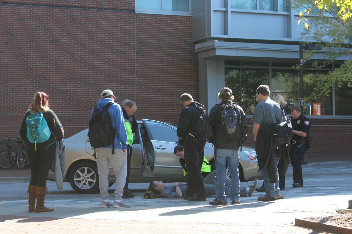 Jason Corder, a senior studying chemistry, receives medical attention after being hit by a car while he was skateboarding in front of SAS Hall.