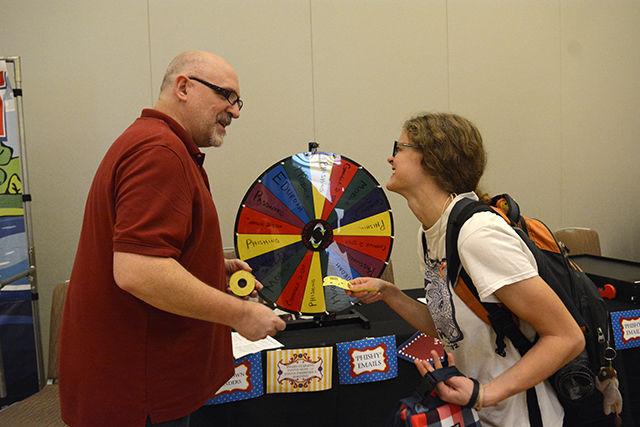 Hannalee Alrutz, a senior studying middle grades language arts &amp; social studies, smiles after receiving tickets from Mark Harben, Security Analyst with the Office of Information Technology, after playing a spin-the-wheel trivia game on cybersecurity at the Make it Your Mission to Stop Phishing Fair in the Mountain Ballroom in Talley Student Union Tuesday, Oct. 4 2016. The fair featured a variety of games, including the trivia game, a phish-themed photo booth, phish tattoos and prizes as well as information on how to keep data safe from phishing attacks. In addition, free popcorn, cotton candy and ice cream were given out. The fair was sponsored by the Office of Information Technology, NC State Department of Computer Science, ePartners Program and the NC State Engineering Foundation. "It's good to know how to keep my digital life safe" Andrea Cooper, a junior studying communication media said about the event.
