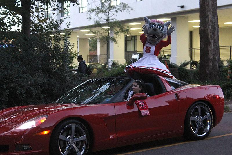 Ms. Wuf rides on a convertible at the front of the homecoming parade on Friday as a part of Red and White Week. NC State's pair of mascots were front and center at the annual parade.