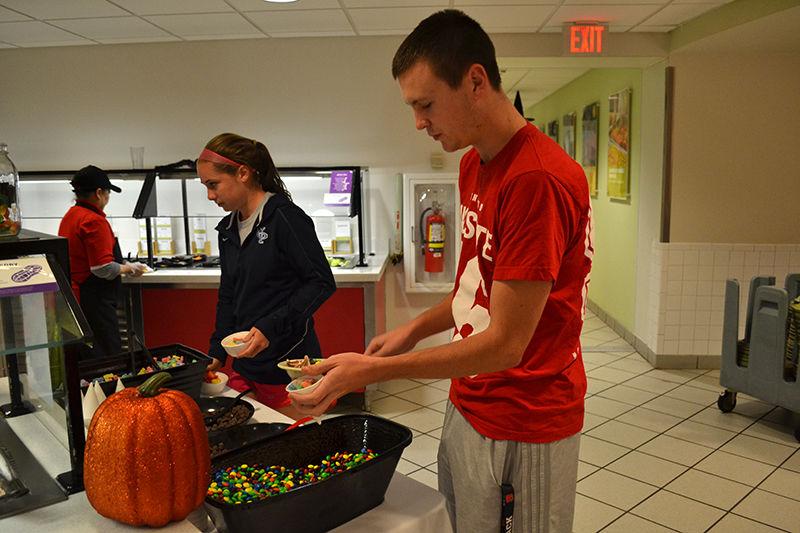 Jacob Seate, a sophomore studying engineering, grabs a scoop of M&amp;M's at the candy station at Clark Dining Hall's Howl-O-Ween event on Monday. Seate said that he had just showed up with no prior knowledge of the event and really liked the dessert station.