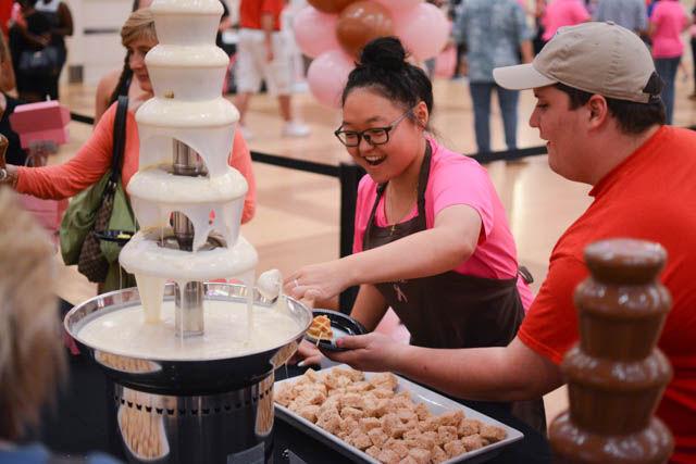 A volunteer helps a Chocolate Festival attendee dip a sweet in the white chocolate fountain at the Chocolate Festival on Friday, Sept. 30 in the State Ballroom in Talley Student Union. Attendees of the Chocolate Festival paid a $10 entrance fee, and sampled a variety of sweets and treats from local vendors. This is the 13th year the NC State Women's Center has hosted the Chocolate Festival, and proceeds from the event go to fund programming within the Women's Center, as well as the Kay Yow Cancer Fund.