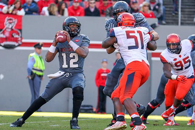 Redshirt Senior Quarterback Jacoby Brissett scans downfield before making a throw against the Syracuse Orange defense. Brissett completed 21 of 33 passes for 235 yards and 2 touchdowns and 1 interception. The NC State Wolfpack beat the Syracuse Orange 42-29 at Carter-Finley Stadium on Saturday, November 22, 2015 to go to a record of 7-4 with a conference record of 3-4.