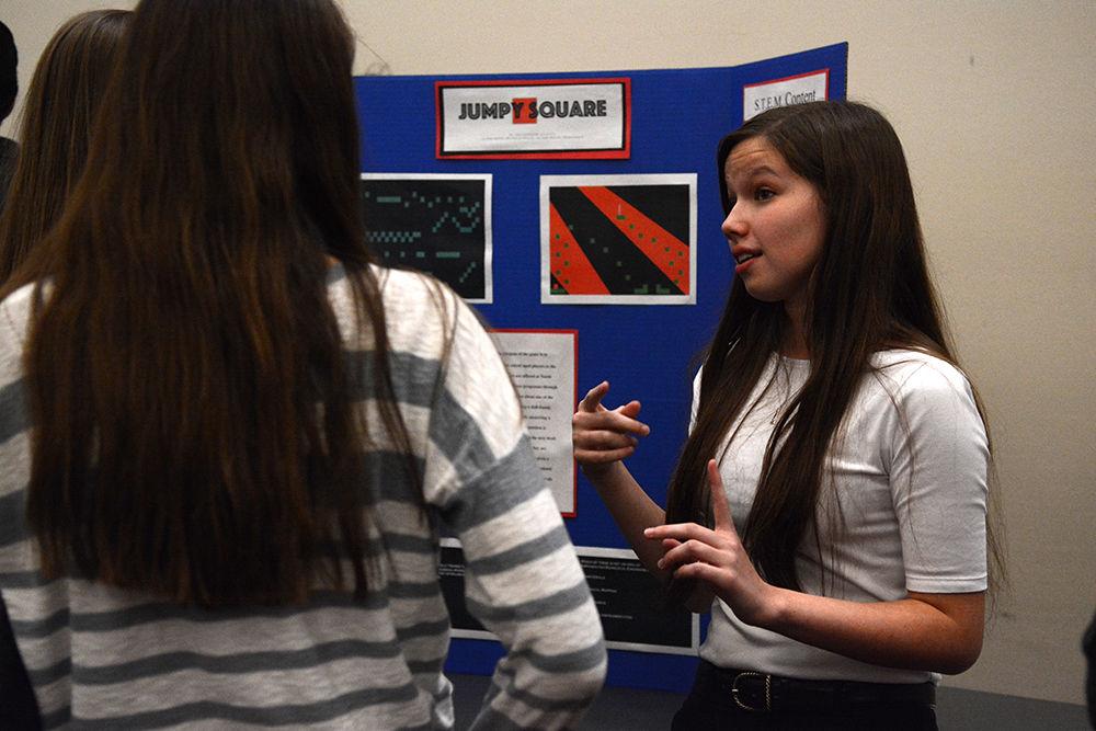 Freshman engineering student Allison Brame discusses the "Jumpy Square" design project at Freshman Engineering Design Day (FEDD) in the McKimmon Center on Tuesday. FEDD gave students the opportunity to compete for awards in different categories of design projects, including educational computer games, nuclear reactor probes, bubble-blowing machines and mechanical music machines.