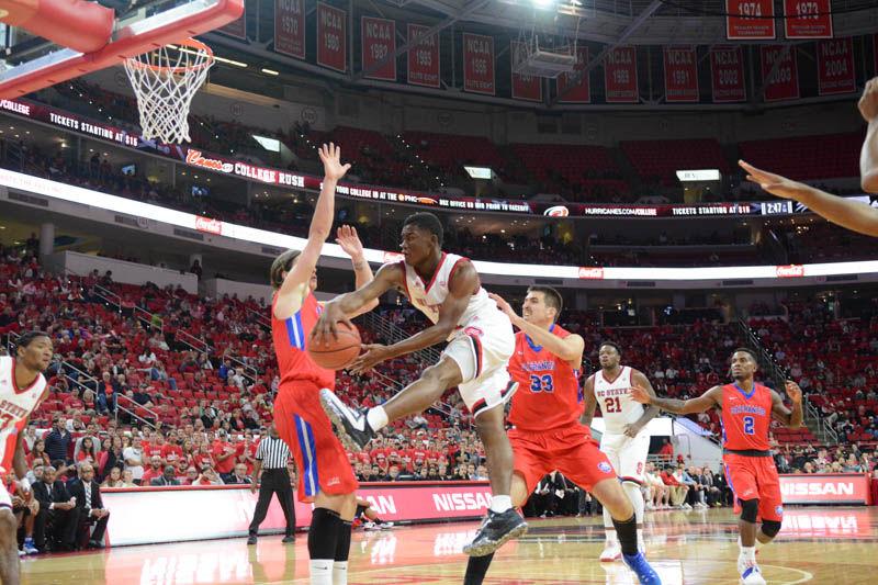 Freshman guard Markell Johnson flies through the air past St. Francis players Gunnar Olaffson and Jagos Lasic to complete a pass to freshman forward Ted Kapita. Johnson played for 21 minutes against the Terriers in PNC Arena on Nov. 13, 2016. NC State won 86-61 against St. Francis Brooklyn College and improved to a 2-0 record.