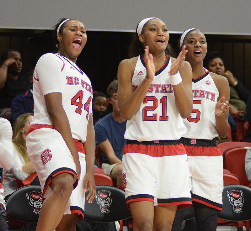 Sophomore center Nae Nae Cole, sophomore forward DD Rogers and junior forward Chelsea Nelson celebrate an NC State point at the Wolfpack's first official home game of the season against Wofford College on Saturday. NC State beat Wofford 80-40 in Reynolds Coliseum.