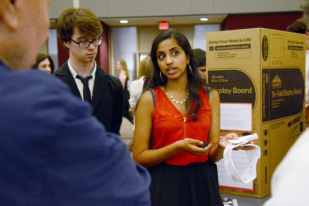 Freshmen studying engineering Thomas Alexander and Chandra Manivannan explain their project to visitors at Freshman Engineering Design Day (FEDD) in the McKimmon Center on Nov. 22. FEDD allowed freshman engineering students to present their design projects to the public and compete for awards.