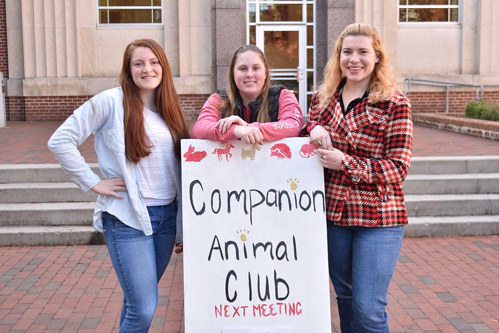 Whintey Chandler, fundraising chair, Emily Summers, Agri-Life representative, and Virginia-Lynne McKean, president of the Companion Animal Club, all pose with the club sign. The NCSU Companion Animal Club is for those who are interested in enhancing their knowledge of companion animals, spending time with people with similar interests, and celebrating the contributions made by pets to the emotional and physical well-being of their owners.