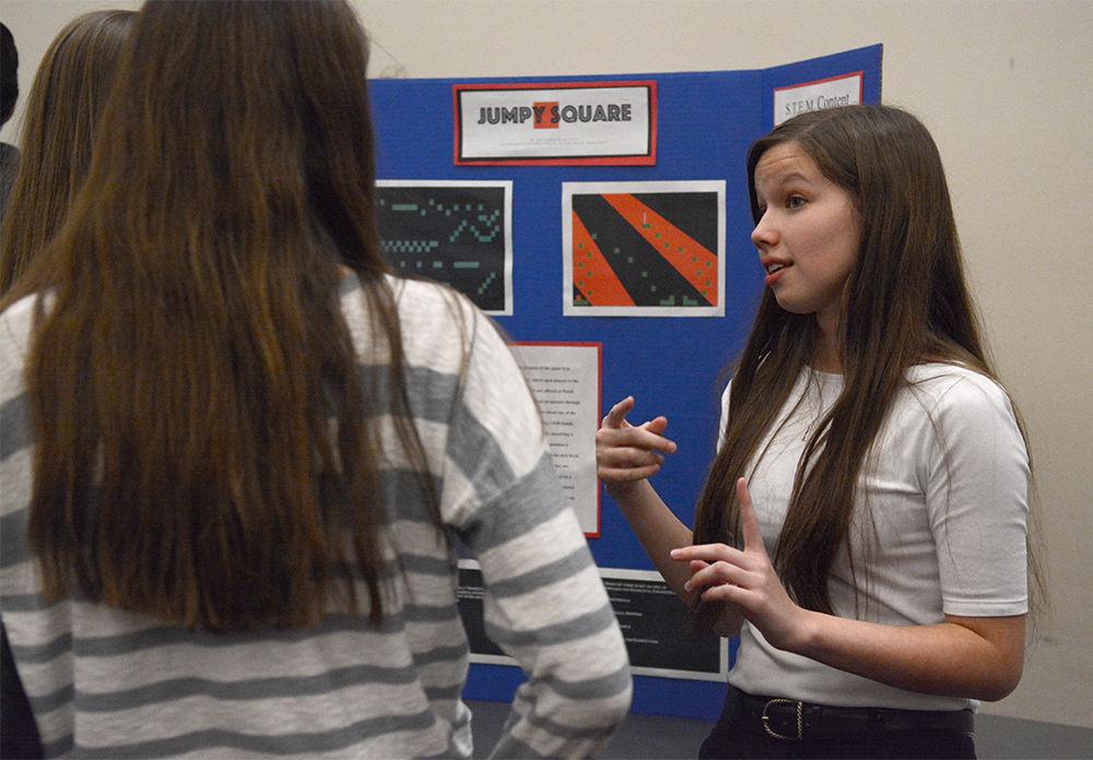 Allison Brame, a freshman studying engineering, discusses the "Jumpy Square" design project at Freshman Engineering Design Day (FEDD) in the McKimmon Center on Nov. 22. FEDD gave students the opportunity to compete for awards in different categories of design projects, including educational computer games, nuclear reactor probes, bubble-blowing machines and mechanical music machines.