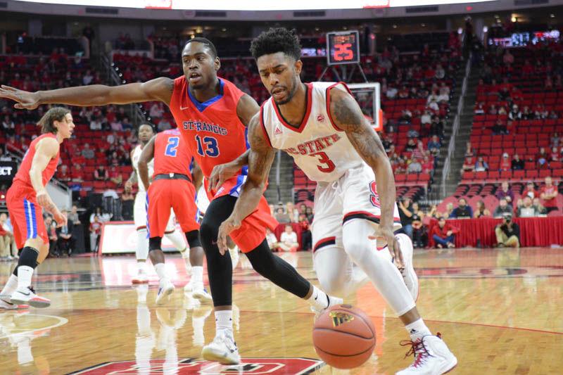Redshirt senior guard Terry Henderson drives past St. Francis's Keon Williams in the men's basketball game between NC State and St. Francis Brooklyn College in PNC Arena on Nov. 13, 2016. Henderson played for 35 minutes, the longest of any of his teammates, and scored 11 points in the Wolfpack's 86-61 win over the Terriers.