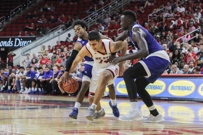 Freshman center Omer Yurtseven outmaneuvers Lynn University players. Yurtseven's debut was well rounded with six points, five rebounds and two blocks in his 17 minutes of play. The Wolfpack took down Lynn University 100-66 in PNC Arena on Thursday.