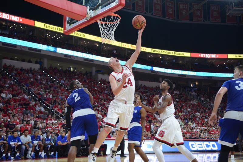 Sophomore guard Maverick Rowan struggles for two points up against Lynn University. Rowan had a total of 17 points throughout the game. The men's basketball team took their first win with a final score of 100-66 in PNC Arena on Thursday.