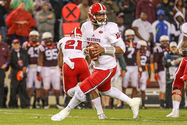 Redshirt Senior quarterback Jacoby Brissett scrambles out of the pocket with multiple Hokies players in pursuit behind him. Brissett went 12 for 25 passing and 133 yards with one touchdown and one interception. The Wolfpack lost to the Hokies 28-13 at Virginia Tech in Lane Stadium on October 9th, 2015.