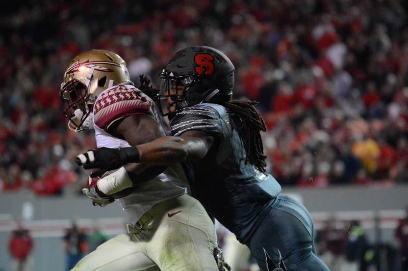 Senior defensive back Dravious Wright tackles a Florida Seminoles player. Wright led the team with a total of ten tackles during the football game on Saturday. The game at Carter-Finley Stadium was won by the Seminoles by a score of 20-24.