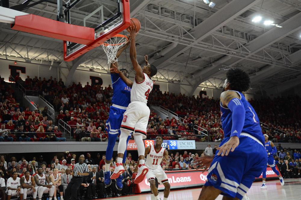 Freshman guard, Dennis Smith Jr., goes up for a dunk against a TSU player. Smith scored a total 19 points during the game against Tennessee State University at Reynolds Coliseum. The Wolfpack won the game on Saturday, December 10, 2016, with a score of 67-55.