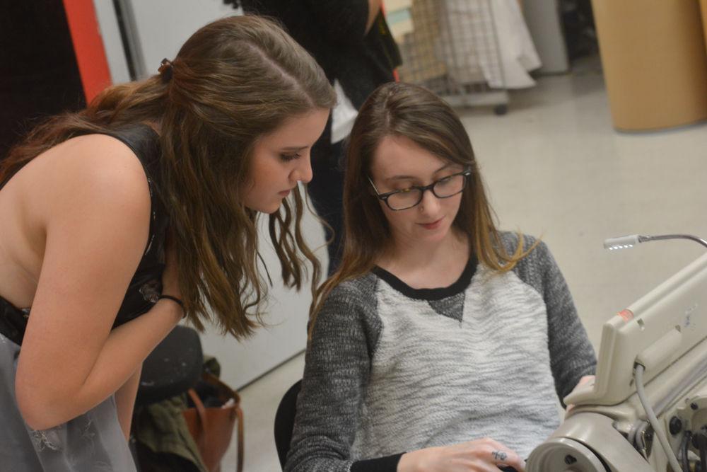 Hannah Broders, a junior in Fashion and Textile Management walking in the undergraduate showcase, and Breanne Bogner, a senior in Fashion and Textile Management work on a garment backstage at the COT Threads Senior Showcase. The fashion show went on in the atrium of the College of Textile on Dec. 3, 2016