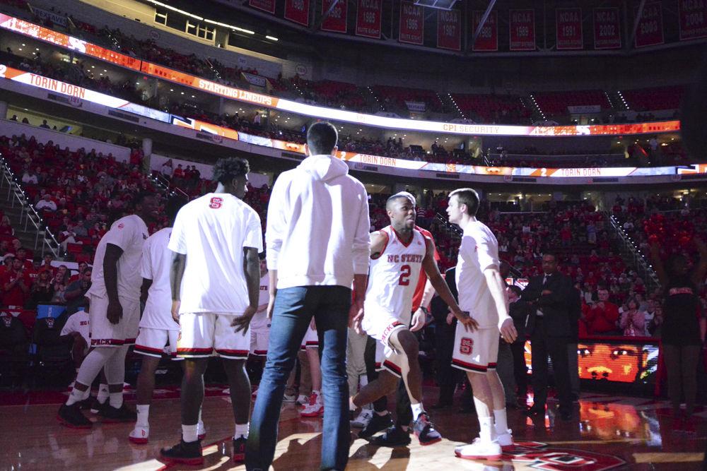 Players of the Men's Basketball team welcome in starter Torin Dorn. The Wolfpack had a win over Boston University in their game on Saturday in PNC Arena making them 5-2 overall.