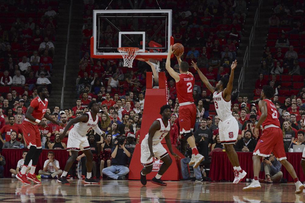 Senior Terry Henderson attempts a block versus Tyler Scanlon of Boston University. The Men's Basketball team had a close win over Boston University with a final score of 77-73 in PNC Arena on Saturday.
