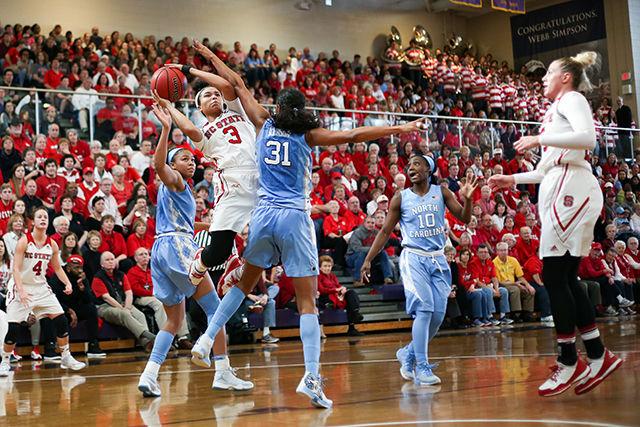 Junior guard Miah Spencer is contested by the UNC defense as she goes up for a jumper. Spencer put in a strong performance with 20 points and eight rebounds in her 29 minutes of play. The Wolfpack dominated the Tar Heels coming out with a 78-49 win in Holliday Gymnasium at Broughton High School Sunday.