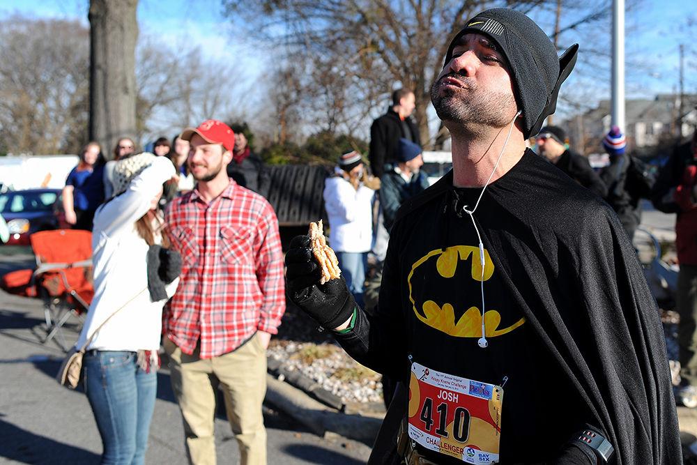 Josh Franceschina, then-senior studying environmental sciences, eats a doughnut while wearing a Batman costume at Krispy Kreme on Feb. 14, 2015. Franceschina was a runner in the 11th annual Krispy Kreme Challenge, which was won with a time of 28 minutes and 50 seconds.