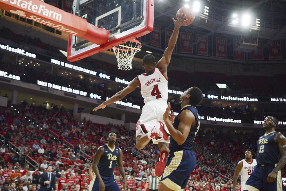 Freshman guard Dennis Smith Jr. flies through the air while dunking on Pittsburgh's men's basketball team. The Wolfpack took their second ACC win with a final score of 79-74 in PNC Arena on Tuesday.