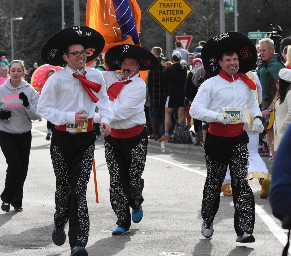 Zach Szolnik, Mark Szolnik and David McCombs finish the Krispy Kreme Challenge strong for the seventh year on Feb. 5, 2016. The 12th annual Krispy Kreme Challenge had around 7,000 runners and raised $195,000 for the UNC Children&#8217;s Hospital.