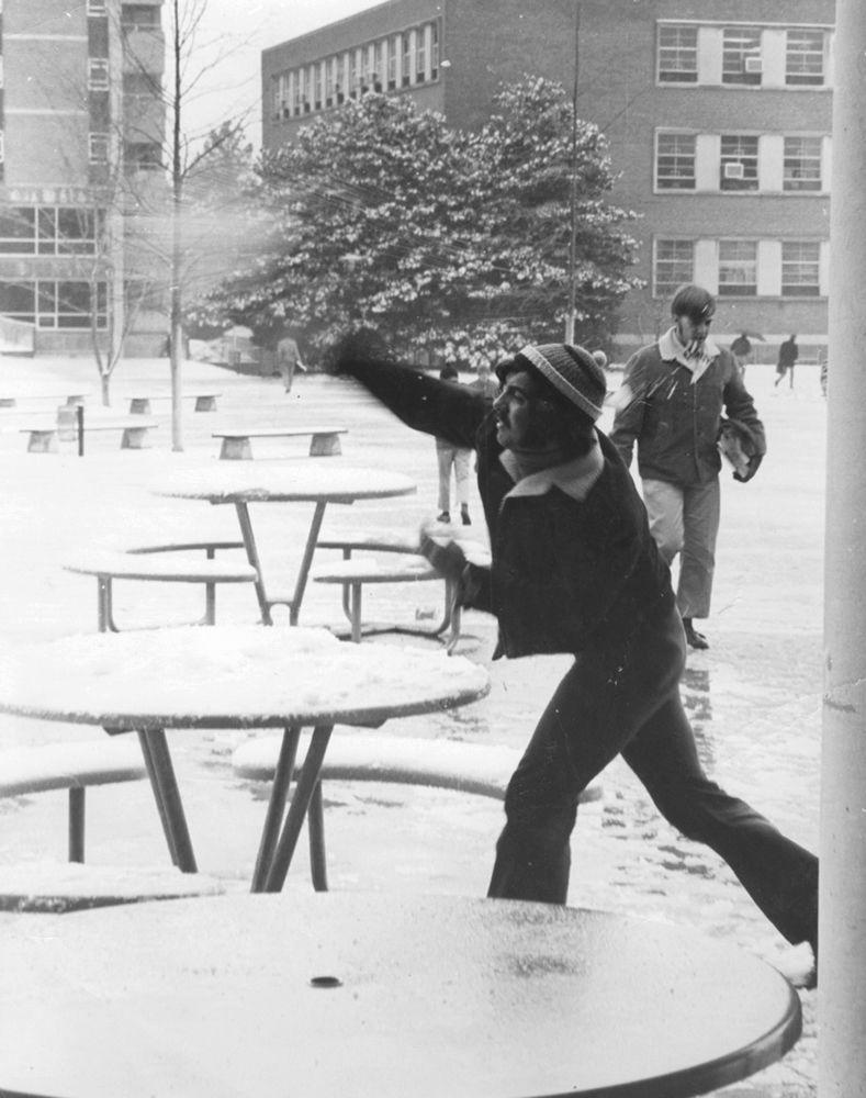 Circa 1977, a student tosses snow in the Brickyard.