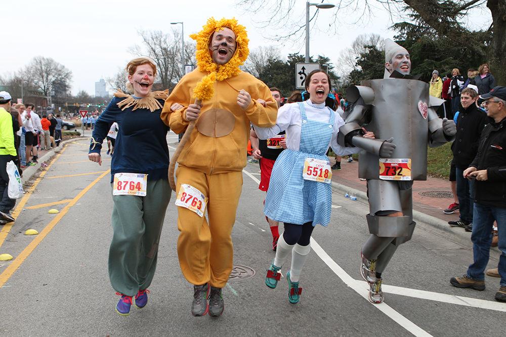 Characters from The Wizard of Oz, portrayed by Heather Mooney, Drew Mooney, Cathy Fromen and challenge runner Marc Kai, cross the finish line at the 10th Annual Krispy Kreme Challenge Saturday, Feb. 8, 2014. Runners dress up in costumes for the race. Other costume themes included Pac Man, Mario Kart and super heroes.