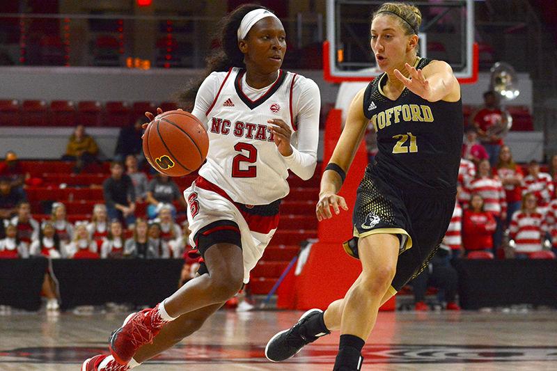 Redshirt freshman guard Kaila Ealey drives the ball past the Wofford guard, senior Maria Corella, in the Reynolds Coliseum on Saturday. Ealey scored total of nine points with four rebounds and two assist in her 19 minutes of play. The Wolfpack ended their opening game against Terriers with victory of 80-40.&#160;