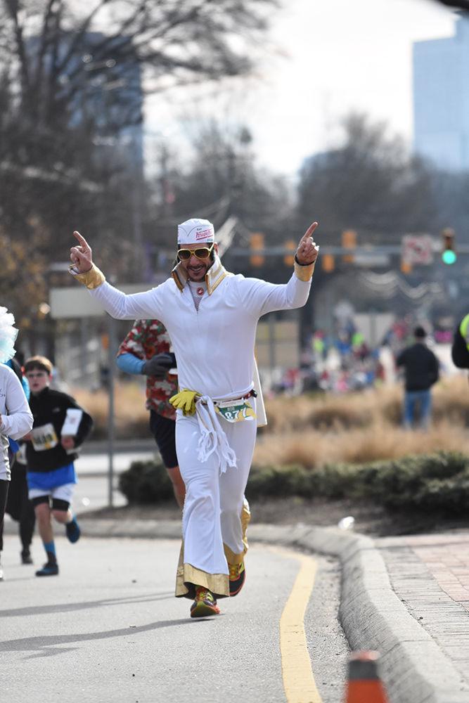 Bob Willix starts to celebrate as he crosses the finish line, on Hillsborough Street near the Belltower, for his eighth Krispy Kreme Challenge, on Feb. 6, 2016. Willix is a year-round competitive runner and runs the Krispy Kreme Challenge because he says that it is a fun run and it is for a great cause.