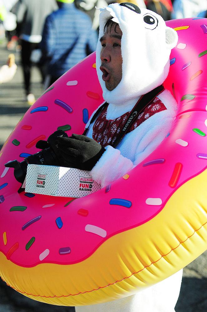 Chris Chao is seen in costume with a doughnut and camera as he completes the Krispy Kreme Challenge. The Krispy Kreme Challenge consists of running 2.5 miles, eating a dozen doughnuts, and running another 2.5 miles.