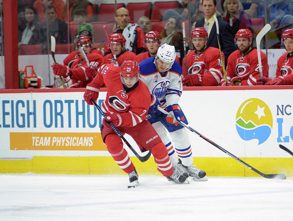 Hurricanes forward Sebastian Aho fights the puck off of Oilers defender Oscar Klefbom. The Hurricanes defeated the Oilers 2-1 in PNC Arena on Friday with a goals from Aho and forward Elias Lindholm.