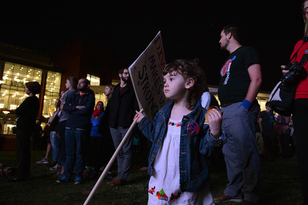 A young supporter holds a sign reading "diversity makes us stronger" on one side and "I love international students" on the other at the United Not Divided rally held on Stafford Commons on Monday. The rally was hosted by various student organizations including the Muslim Students Association, Iranian Student Associations and Latin American Student Association and featured student and faculty speakers.
