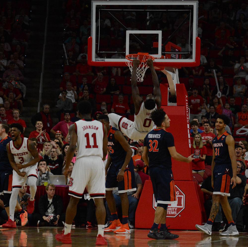 Junior Abdul-Malik Abu swings from the rim after dunking over the team from Virginia. Abu played well in the game on Saturday and scored a total of 12 points, second behind Dennis Smith Jr. with 13 points overall. The Wolfpack fell to UVA with a final score of 70-55 in PNC Arena in their final home game.