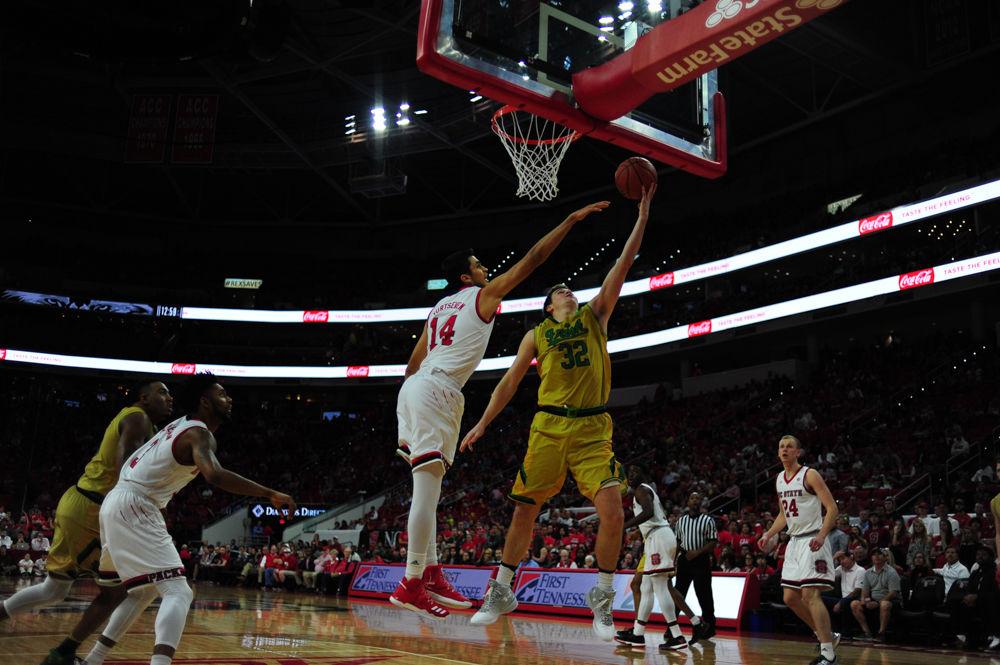 Notre Dame's Steve Vasturia lays the ball in against the Wolfpack's Omer Yurtseven. Vasturia finished the game with 11 points in Saturday's contest.