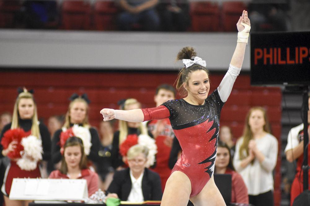 Sophomore Paris Phillips grins while striking a pose during her floor routine. Her performance scored 2nd overall with a 9.875 behind fellow teammate Drew Granthem. Her score helped the Wolfpack to a 2nd place finish behind UNC Chapel Hill at Reynolds Coliseum on Feb. 10.