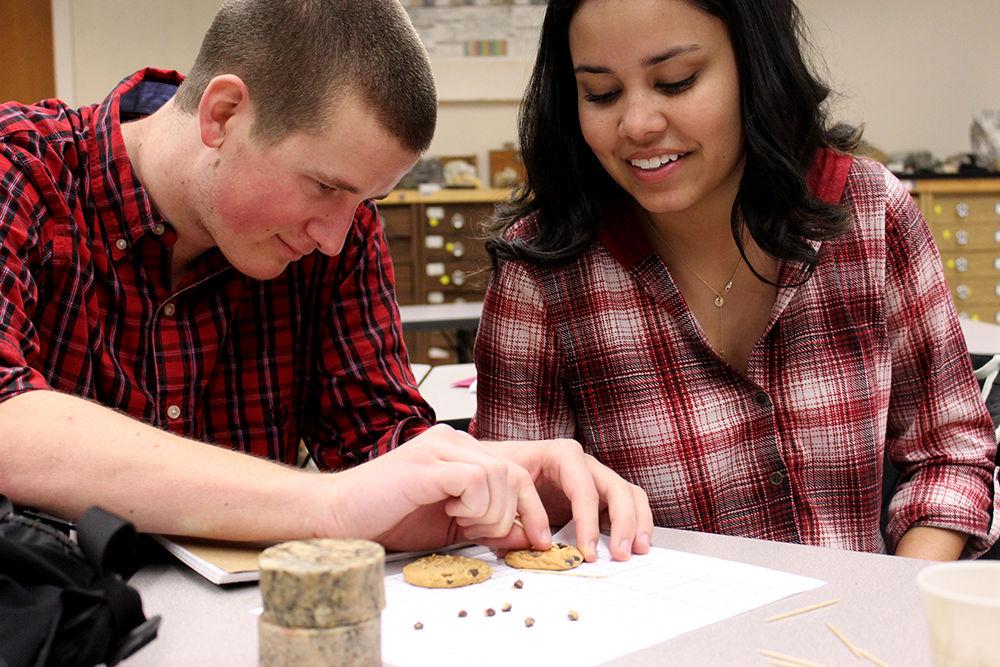 Cooper Green, a freshman studying business, and Sydney George, a freshman studying sustainable materials &amp; technology, "mine" chocolate chips from a cookie during their geology lab in Jordan Hall on Wednesday. The activity was supposed to teach students about how mining in real life is difficult and not profitable. &#8220;It was cool to have an activity that was both educational and delicious,&#8221; George said when asked for her thoughts about the lab.