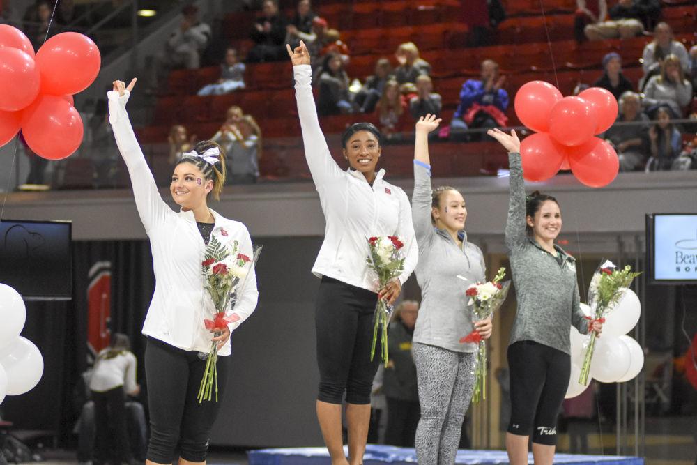 Junior gymnast Chelsea Knight and senior Amanda Fillard wave to the crowds at the top of the podium for their performance in the uneven bars event . Knight finished first overall with a near perfect score of 9.900, with Fillard finishing second overall with 9.875. The Wolfpack came in second overall at the meet with a score of 195.025-195.675 behind UNC Chapel Hill at Reynolds Coliseum on Feb 10.