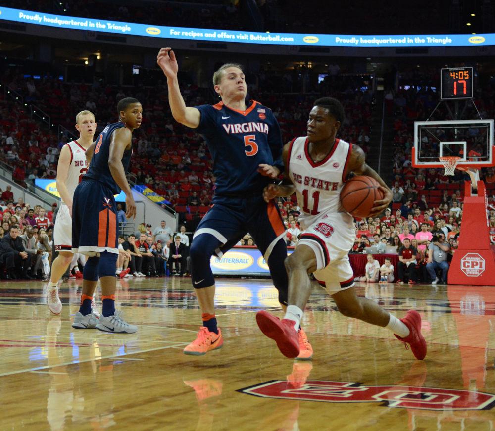 Freshman guard Marquell Johnson dribbles past several players from Virginia. Johnson played a strong game on defense and offense with a total of 11 points and three steals. The men's basketball team lost to UVA with a final score of 70-55 in PNC Arena on Saturday.