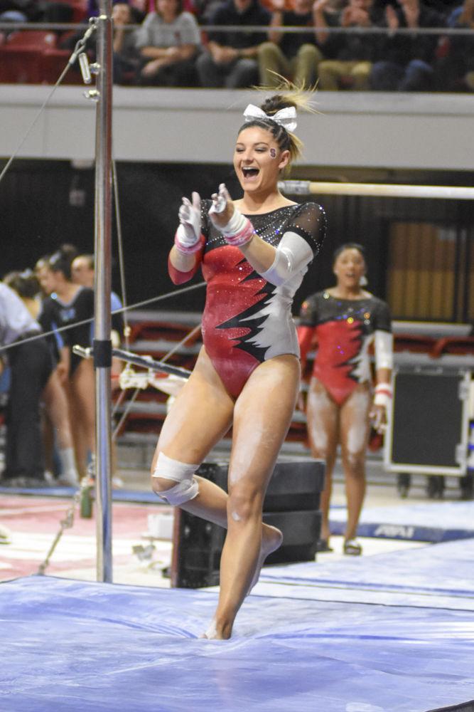 Senior Amanda Fillard claps with a smile on her face after finishing her routine on the uneven bars. She finished second overall on the uneven bars with a score of 9.875, behind teammate Chelsea Knight with a score of 9.900. NC State finished 2nd behind UNC Chapel Hill with a close score of 95.675-195.025 on Feb. 10 at Reynolds Coliseum.