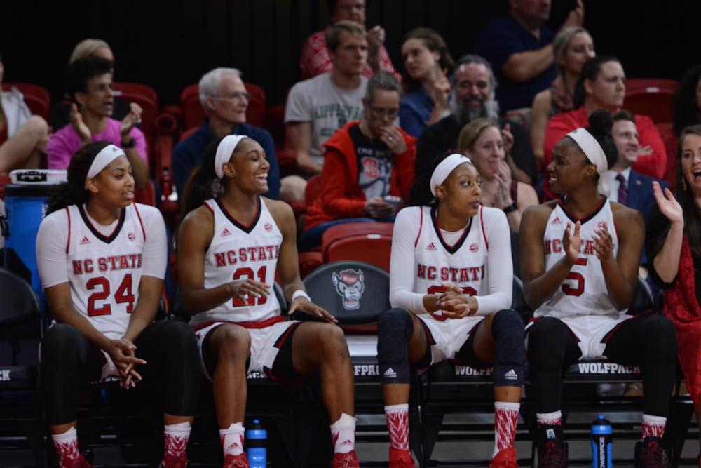 Players, Erika Cassell, DD Rogers, Akela Maize, and Chelsea Nelson celebrate their teammates scoring goals to maintain the lead against UNC-Chapel Hill. The Wolfpack won the game against the Tar Heels with a score of 80-60 in Reynolds Coliseum on February 23, 2017.