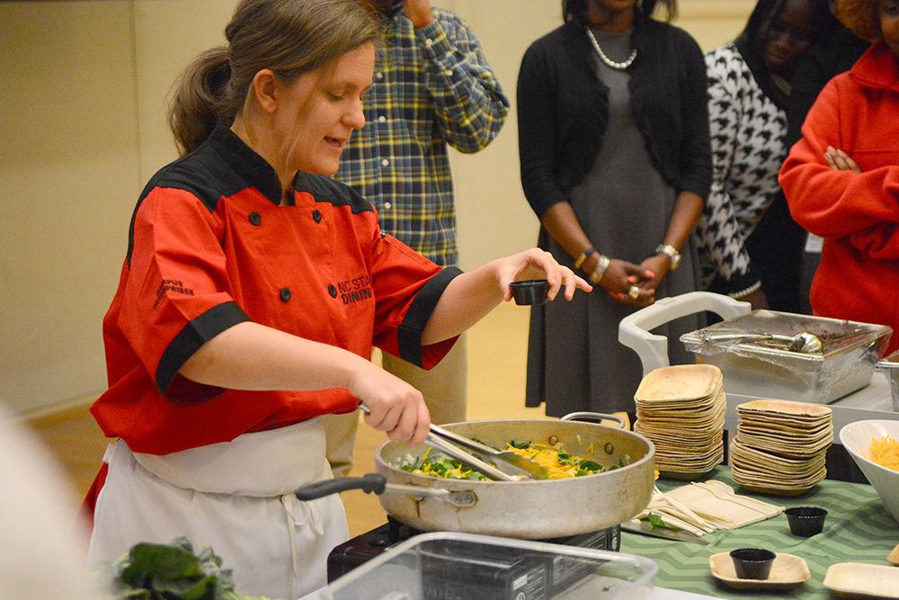 Lesley Stewart, a chef at NC State Dining, demonstrates how to cook healthy "soul foods" at "Food for the Soul" in Talley Student Union's Piedmont Ballroom on Monday. The demonstration was part of a larger event in which participants learned about the effects of traditional "soul foods" and the disproportionate health effects they have on the African-American community. In her demonstration, Stewart used onion, squash and canola oil to create a healthy fried dish served on rice.