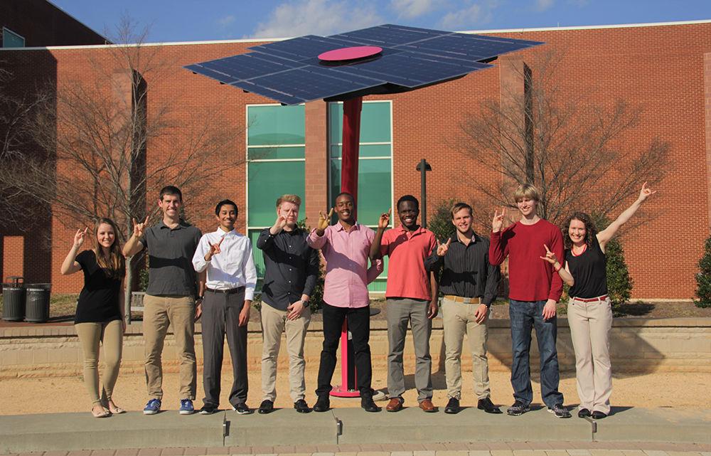 Members of the Solar Pack team celebrate in front of a solar tree on Centennial Campus. The Solar Pack team worked to create a solar powered car to combat widespread pollution.
